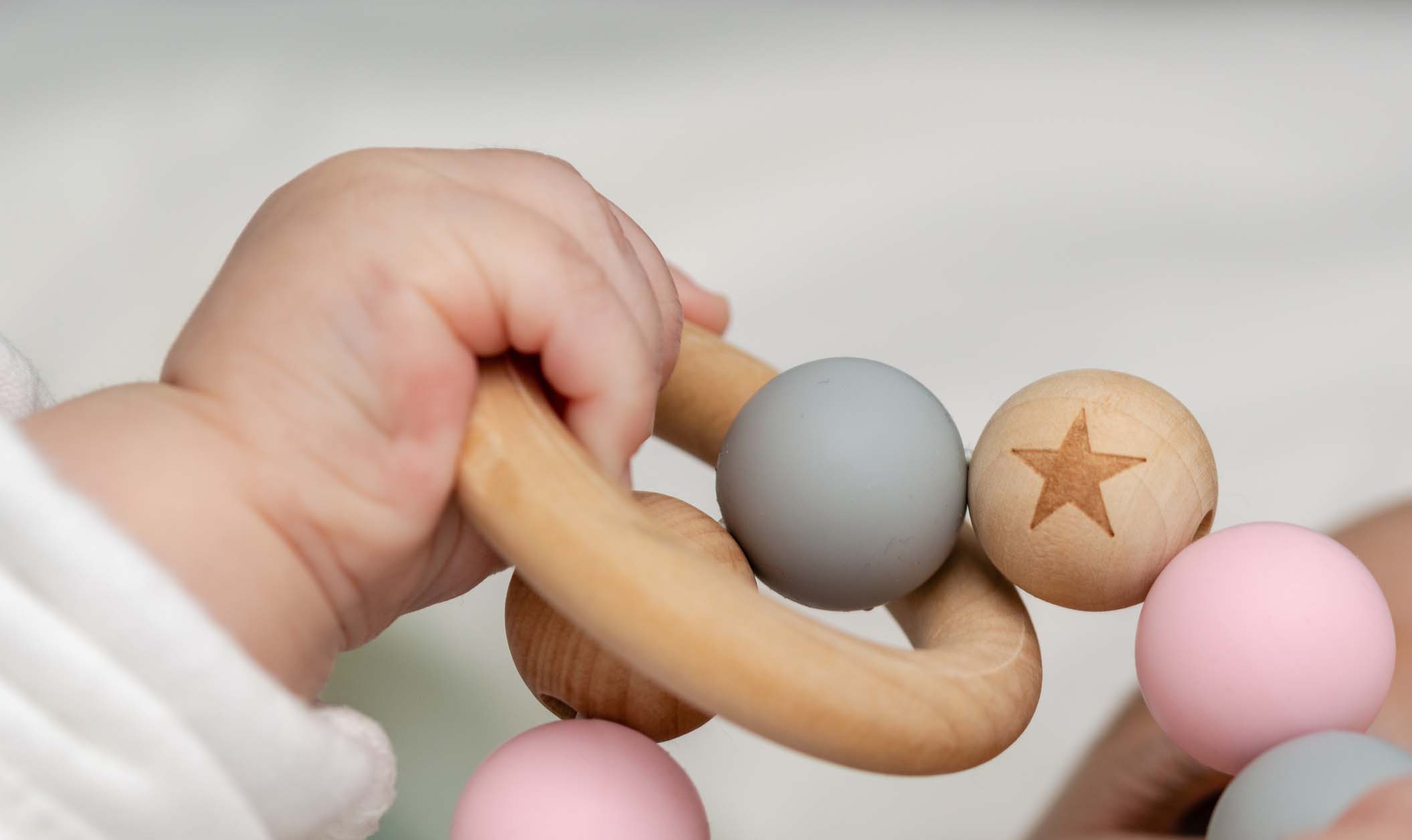 Close-up of a babyÂ´s hand, playing with a wooden toy. Unfocused background